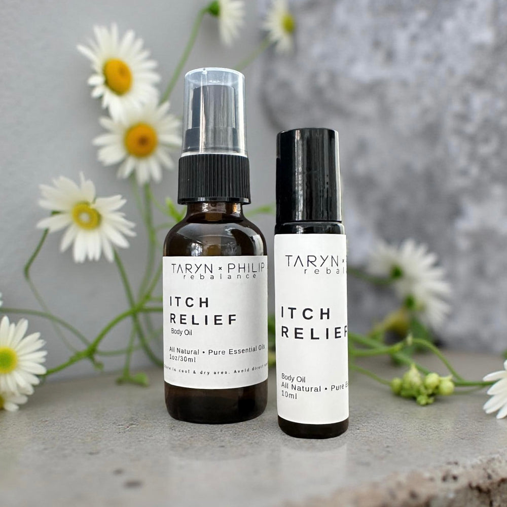 Two bottles of Taryn & Philip Itch Relief Body Oil with daisies in the background.