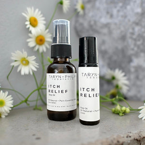 Two bottles of Taryn & Philip Itch Relief Body Oil with daisies in the background.