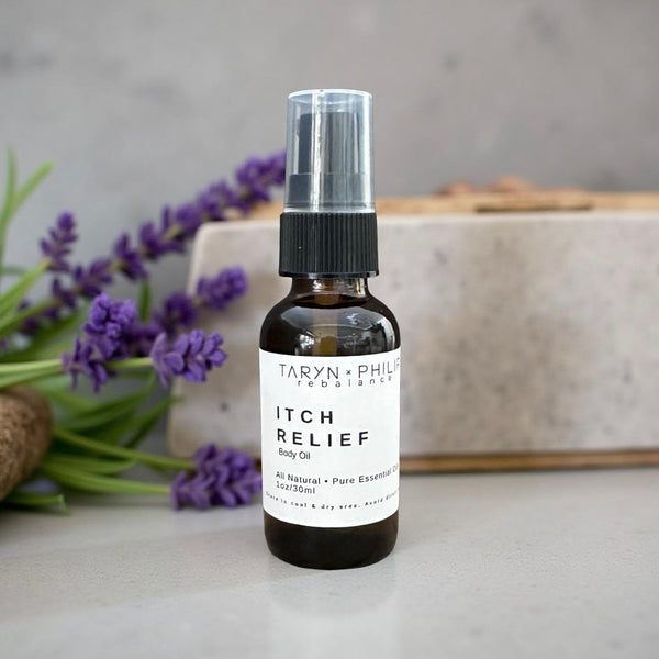 Bottle of Taryn x Philip Itch Relief oil with lavender flowers in the background